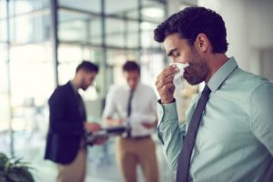 man with sinus infection in an office