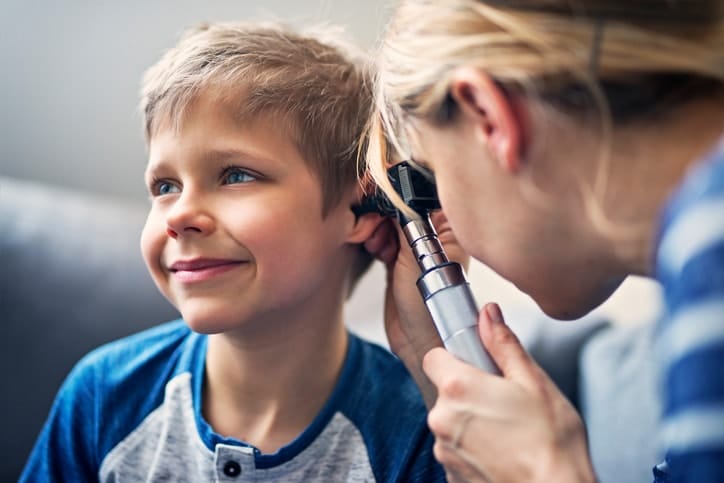 Happy little boy having ear exam