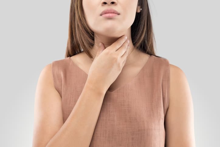 Sore throat woman on gray background
