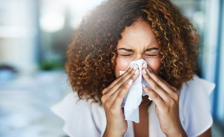 Women blowing nose into tissue