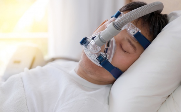 Man Sleeps with CPAP Machine
