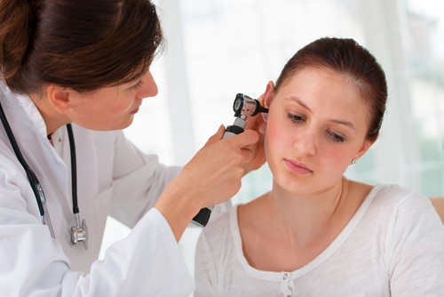 ENT physician looking into patients ear with an instrument